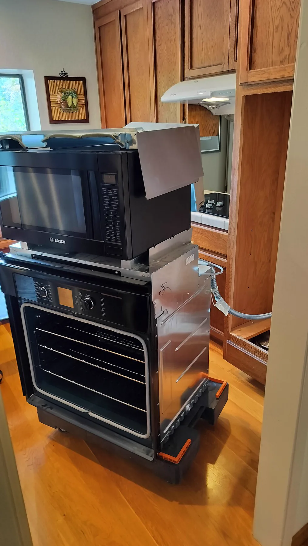 Bosch wall oven pulled out from cabinetry for internal service access.