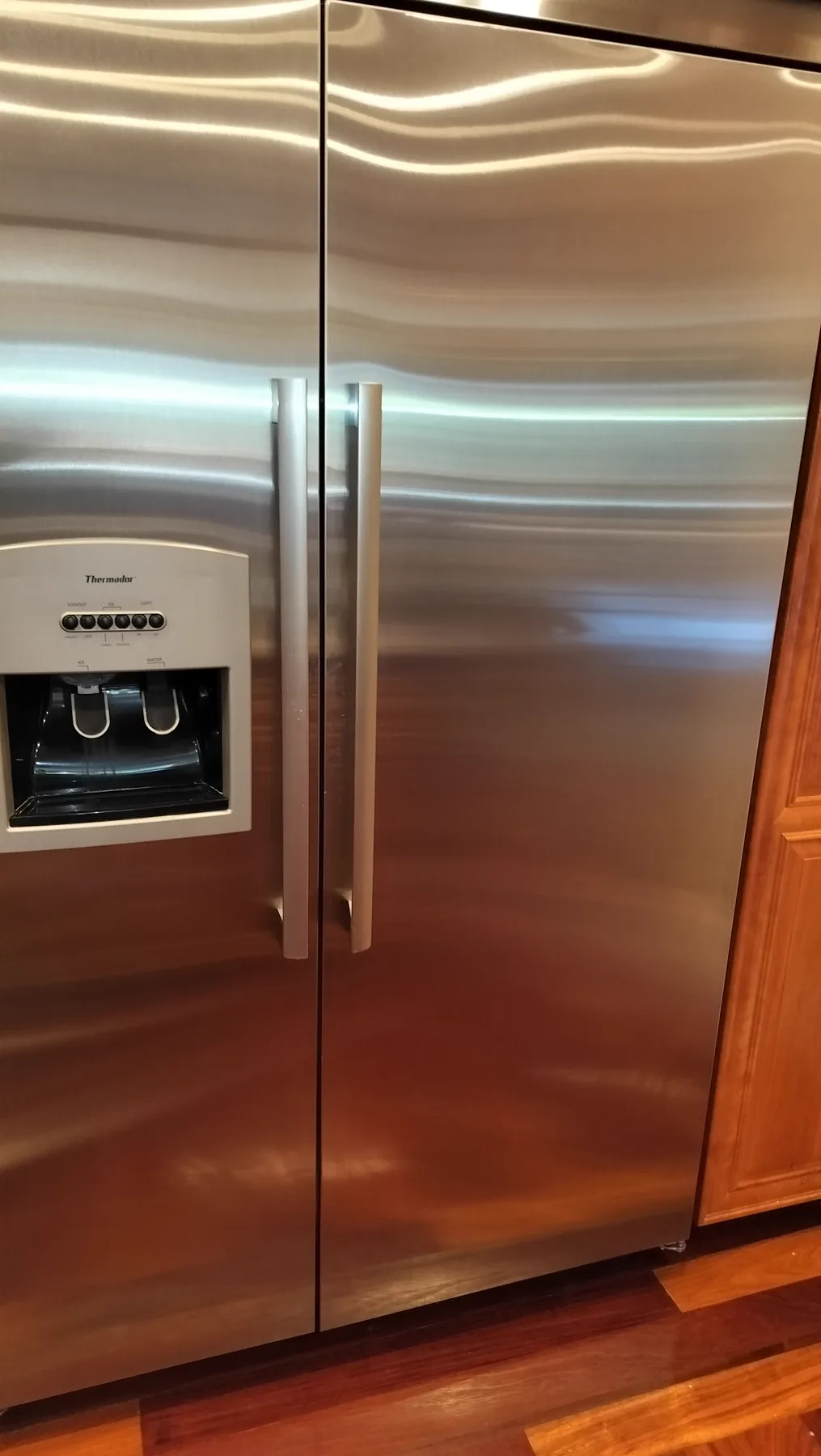Thermador stainless built-in refrigerator in residential cabinetry.