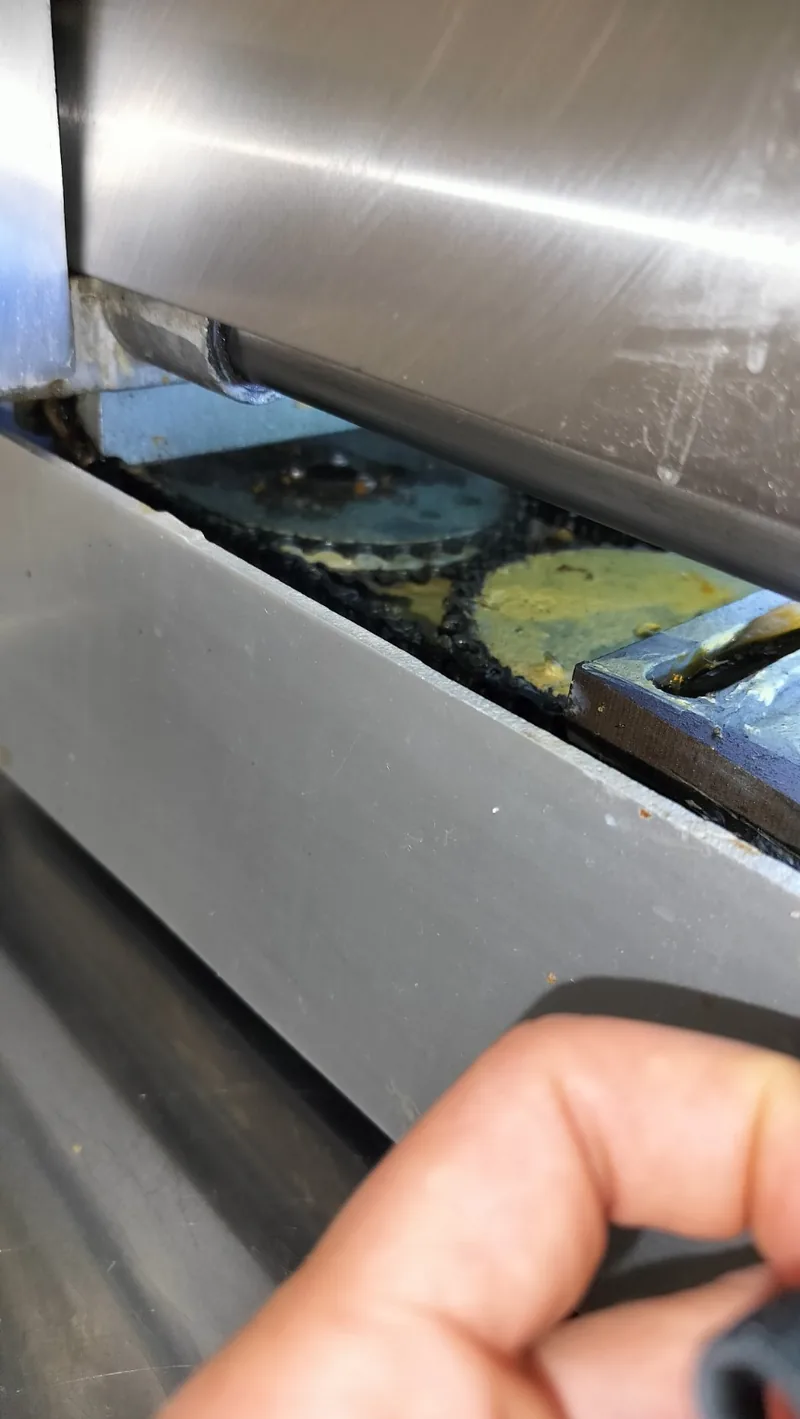 Carriage-drive chain and sprockets visible through the opened slicer housing