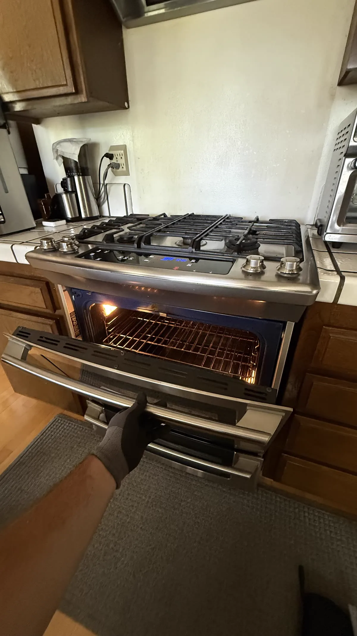 Electrolux slide-in range with the oven door open during a service visit.
