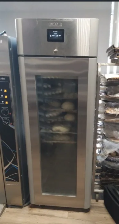 POLAR upright glass-door cabinet beside bakery trays in a commercial workspace.