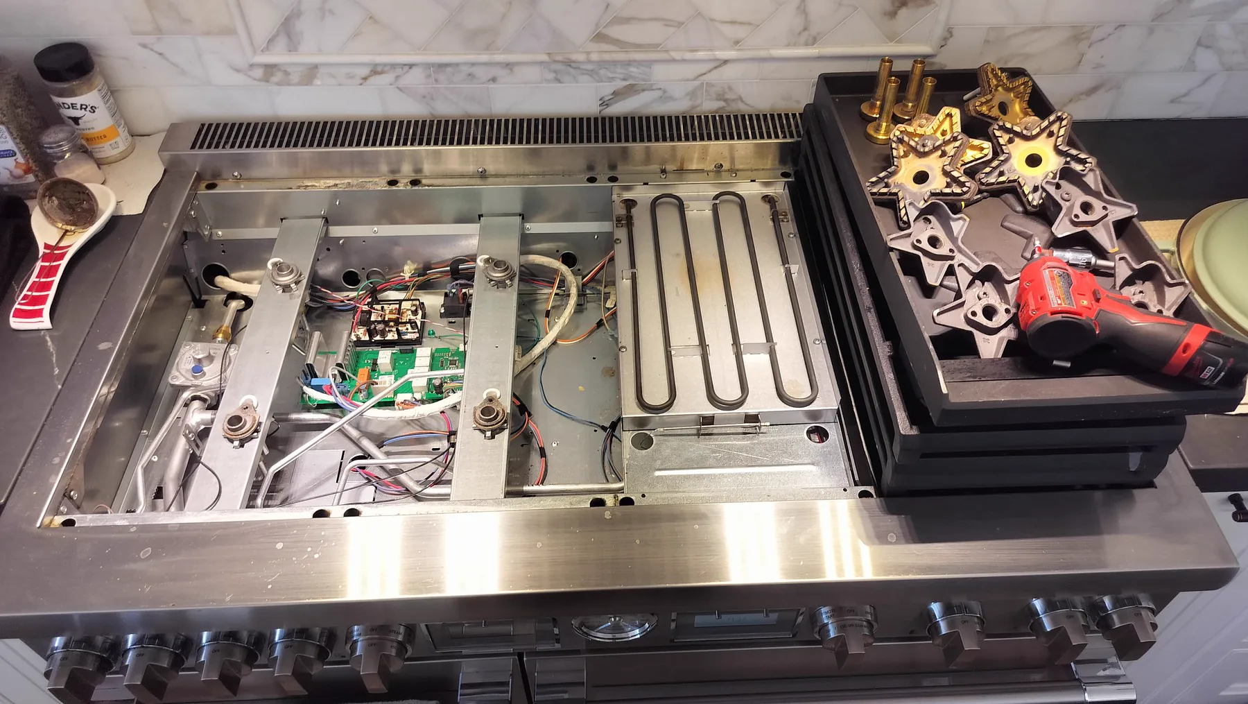 Wolf range with burners and cooking surface removed for internal component inspection.
