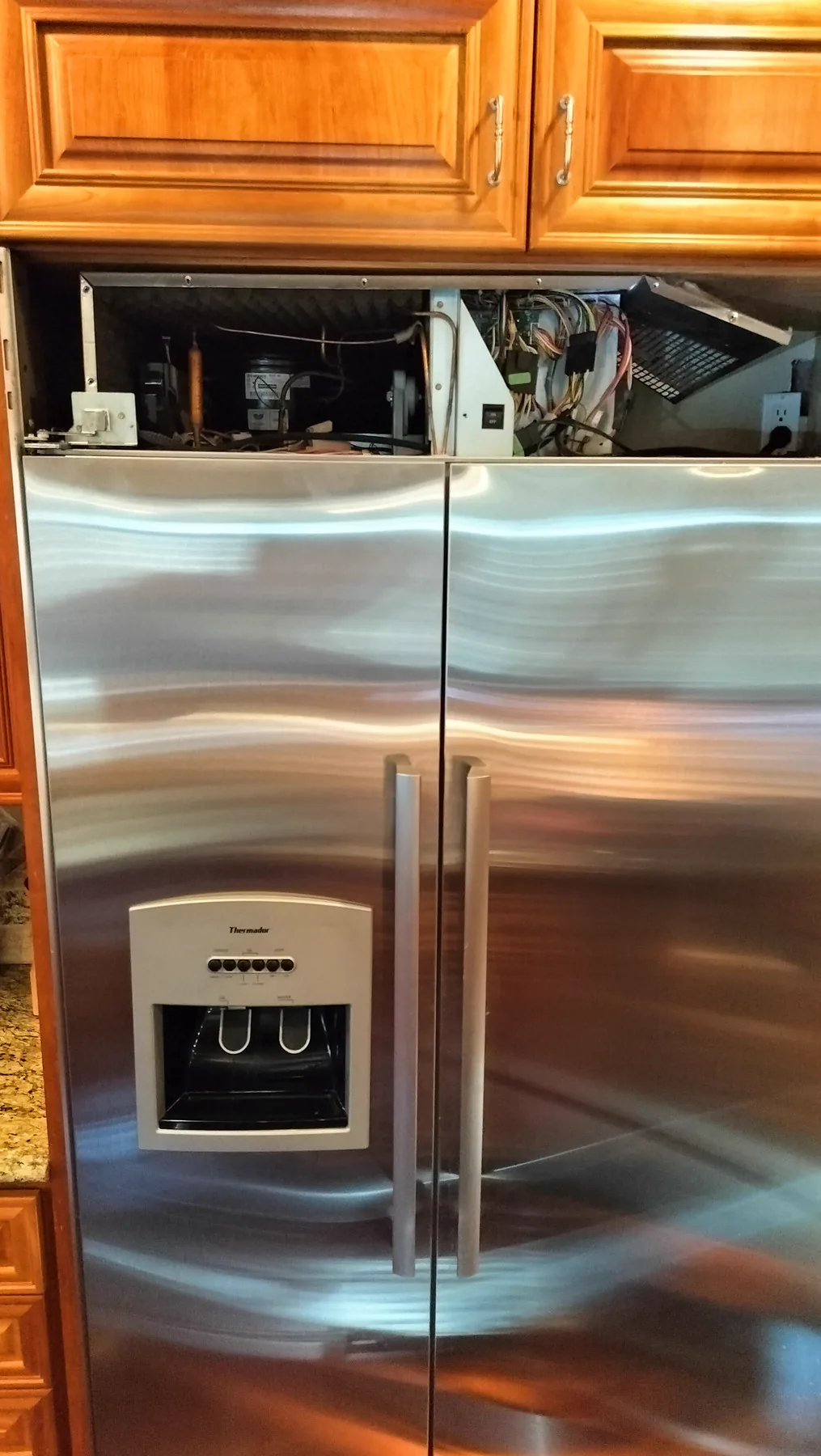 Thermador built-in refrigerator with upper service compartment opened.