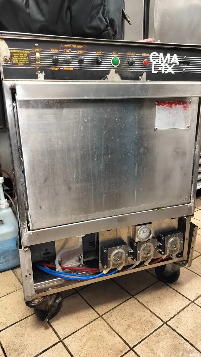 CMA undercounter commercial dishwasher with its lower service panel removed.