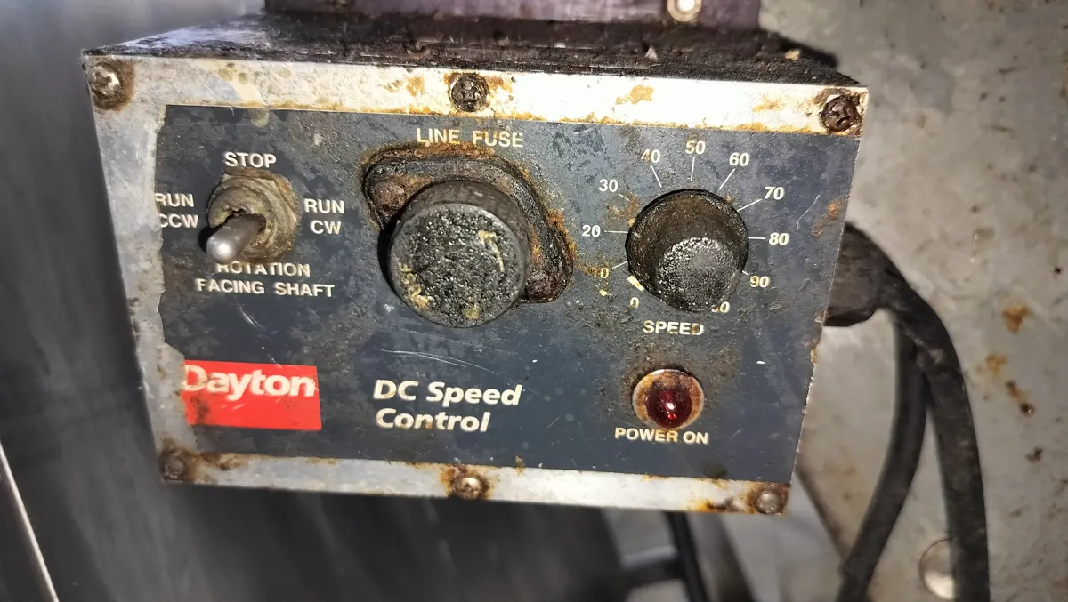 Dayton DC speed control on a commercial tray conveyor, with surface corrosion around the controls.