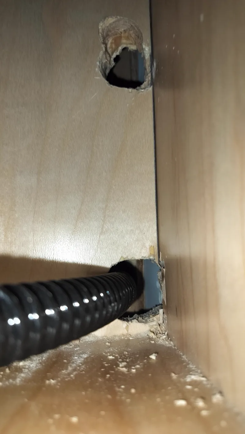 Hidden Gaggenau coffee machine drain hose behind built-in cabinetry