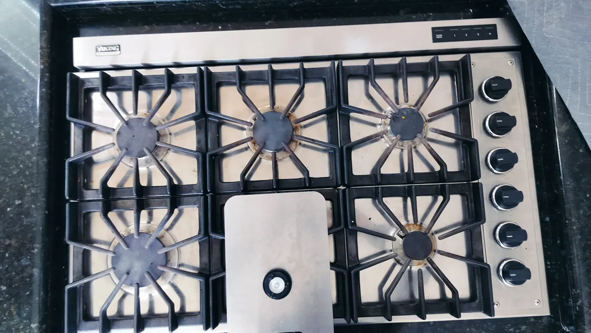 Viking gas cooktop with integrated downdraft and burner controls during an equipment inspection.