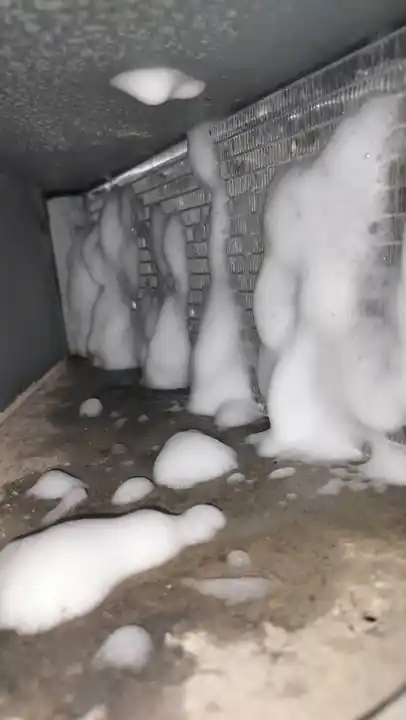 Commercial ice machine condenser during foaming deep-cleaning service.
